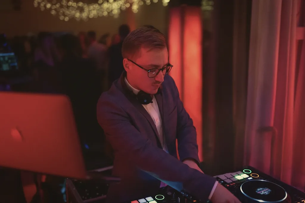 Lars Krukenbaum im Bow-Tie am Pult, konzentriert, warmes rotes Bühnenlicht Lars Krukenbaum im Bow-Tie am Pult, konzentriert, warmes rotes Bühnenlicht