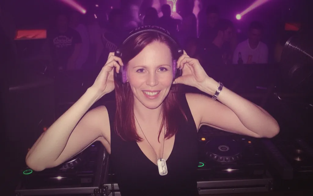 Sabrina Blömer mit Kopfhörern und Lachen, Clubnacht mit lila Bokeh und voller Tanzfläche