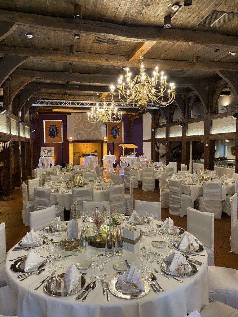 Festsaal Hotel-Residence Klosterpforte Marienfeld mit Kronleuchtern, weiß eingedeckten Hochzeitstafeln und Holzbalkendecke Festsaal Hotel-Residence Klosterpforte Marienfeld mit Kronleuchtern, weiß eingedeckten Hochzeitstafeln und Holzbalkendecke