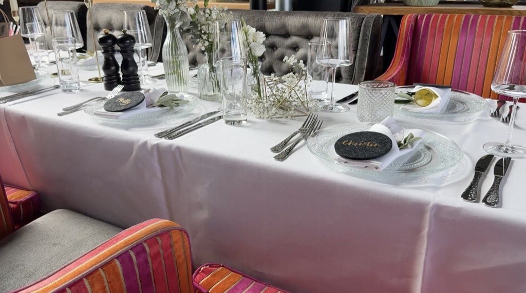 Eingedeckte Hochzeitstafel im The View Restaurant des Lippischen Hofs Bad Salzuflen mit weißer Tischdecke, personalisierten Teller-Tags und farbigen Streifen-Polsterstühlen Eingedeckte Hochzeitstafel im The View Restaurant des Lippischen Hofs Bad Salzuflen mit weißer Tischdecke, personalisierten Teller-Tags und farbigen Streifen-Polsterstühlen
