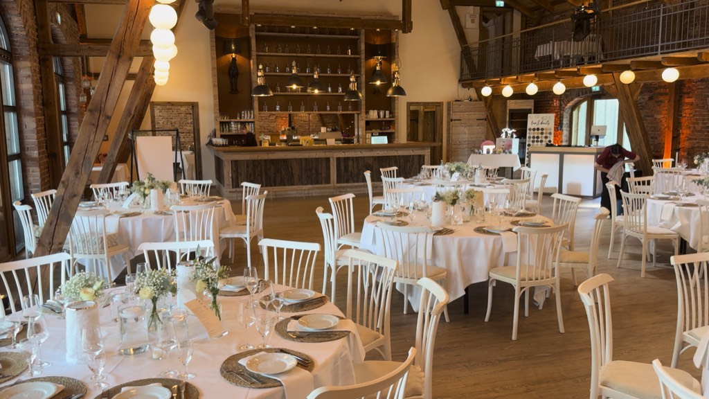 Eventscheune Hof Frien bei Uchte mit Backsteinmauerwerk, hohen Holzbalken, eingedeckten runden Hochzeitstafeln und Bar mit warmem Licht und Lichterketten Eventscheune Hof Frien bei Uchte mit Backsteinmauerwerk, hohen Holzbalken, eingedeckten runden Hochzeitstafeln und Bar mit warmem Licht und Lichterketten